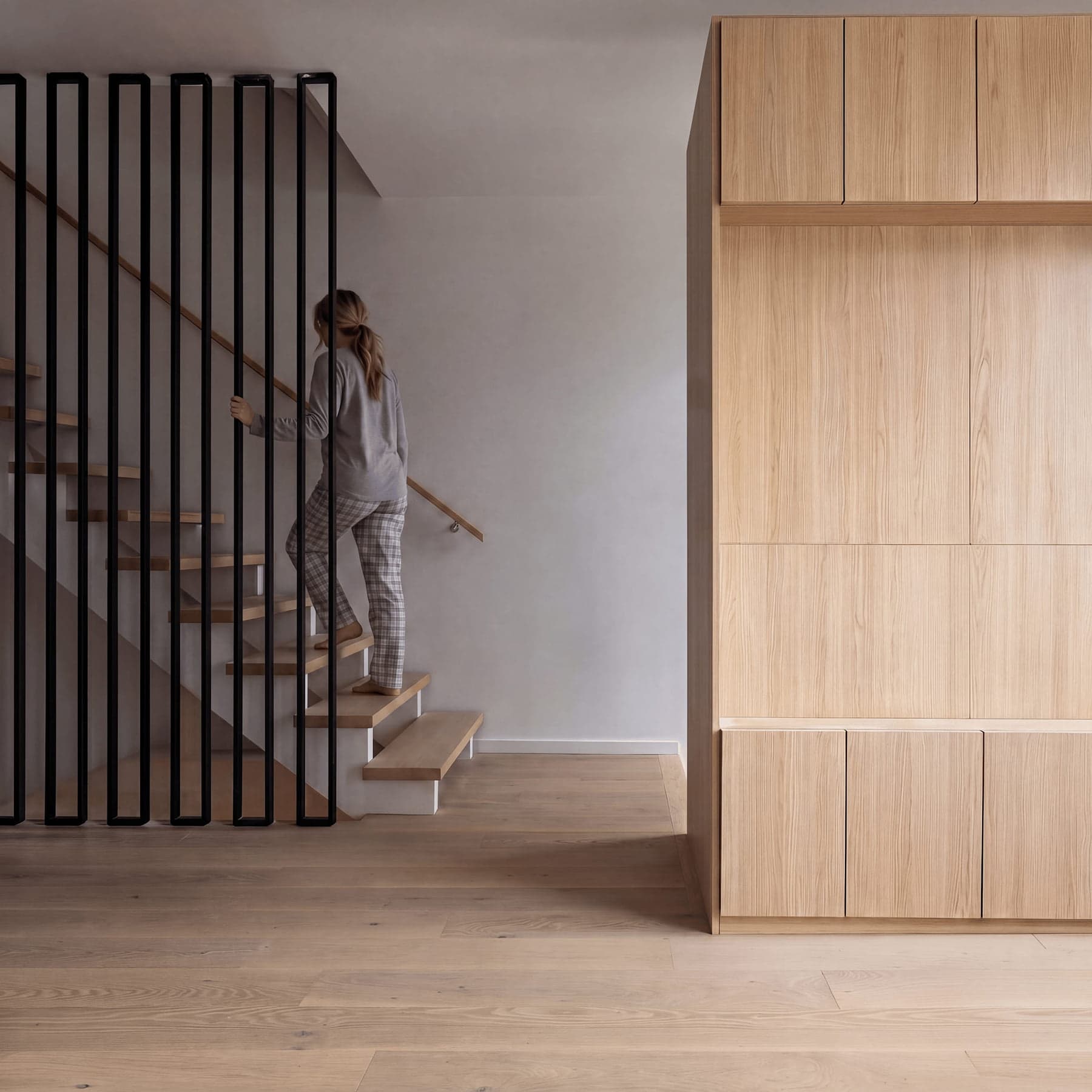 View of a the interior of modern home with staircase and wooden storage unit in North Riverdale, Toronto by baukultur/ca