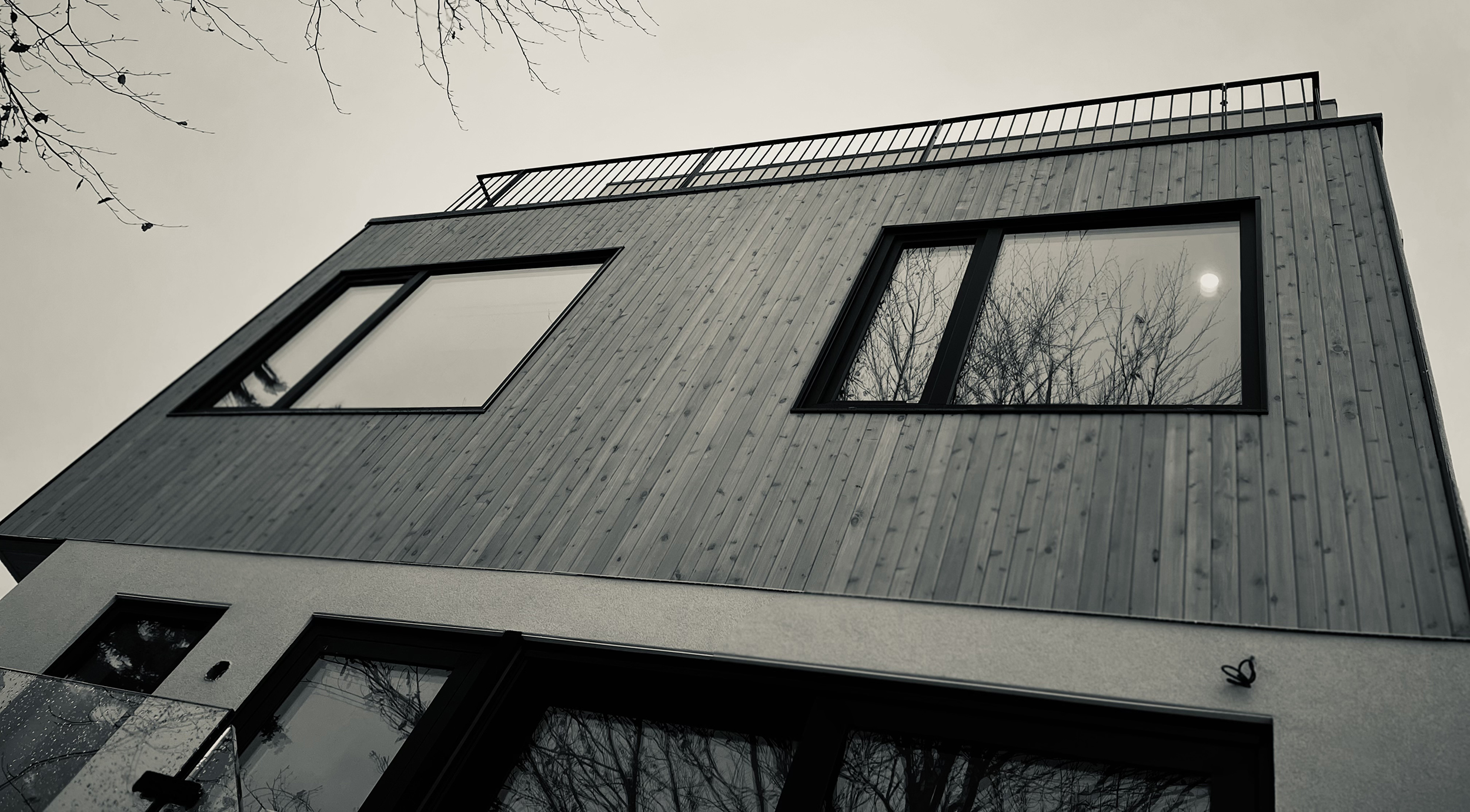 Upward view of the wood-clad 2nd floor at Haus A36 — multiplex with laneway suite in Playter Estates, Toronto by baukultur/ca.